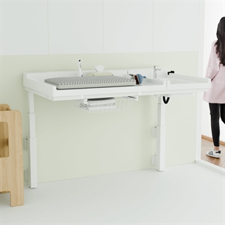 Miljøbillede med Conset BWR129 vægmonteret puslebord med vask og hæve/sænkefunktion i hvid.