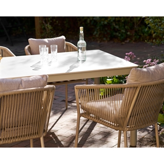 Miljøbillede med Alcudia spise-/havebord i sandfarvet aluminiumsstel og sintret stenbordplade fra House Nordic.