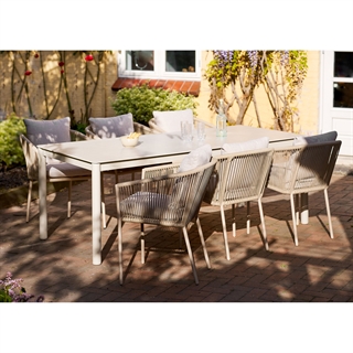 Miljøbillede med Alcudia spise-/havebord i sandfarvet aluminiumsstel og sintret stenbordplade fra House Nordic.