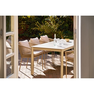 Miljøbillede med Alcudia spise-/havebord i sandfarvet aluminiumsstel og sintret stenbordplade fra House Nordic.