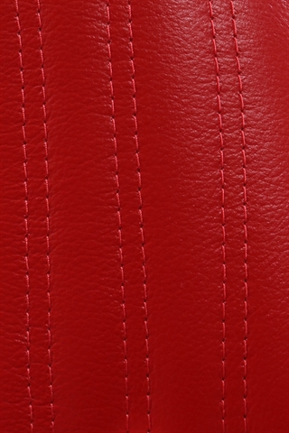 Det røde læder med designsyninger set tæt på.